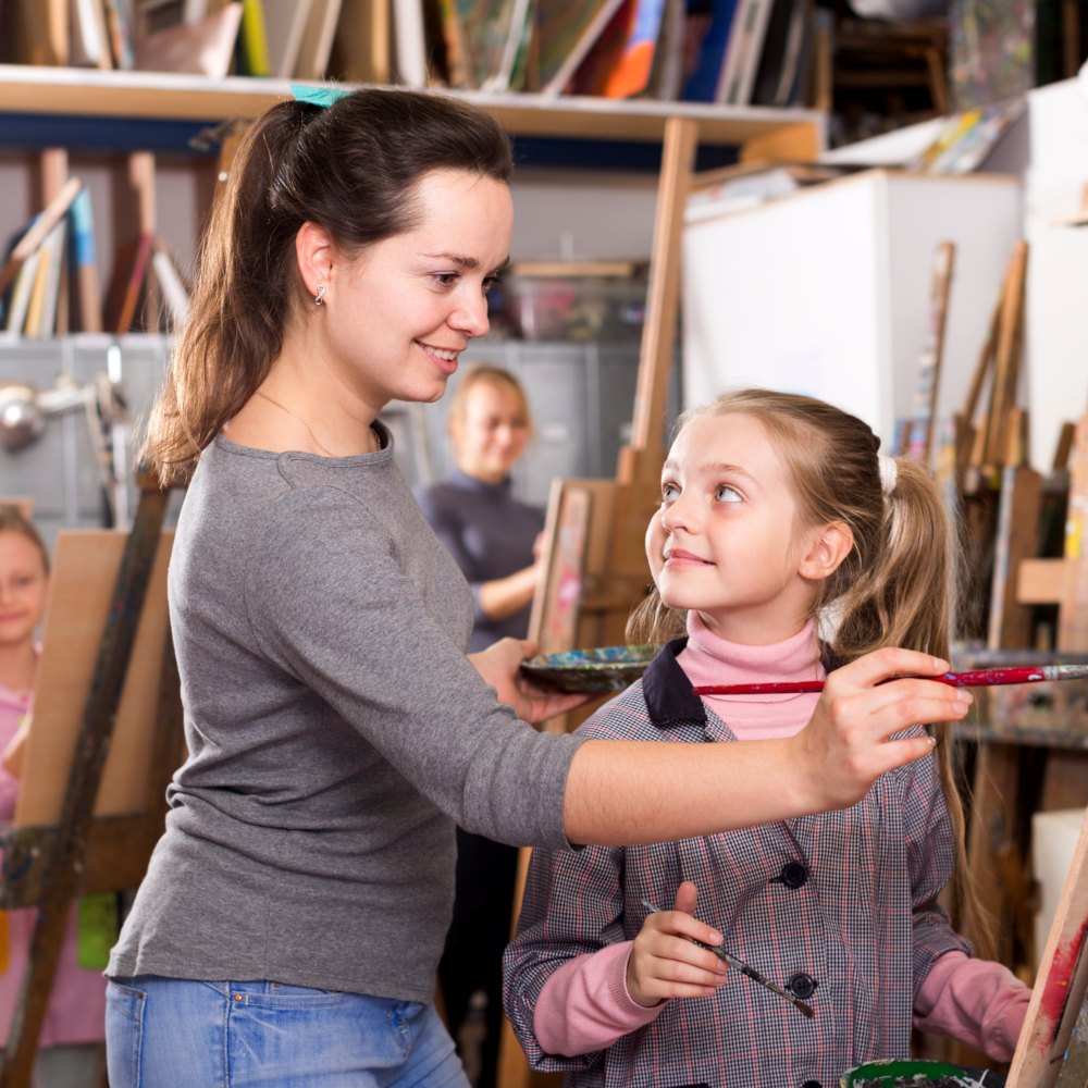 Docente vocacional enseña a pintar a una niña