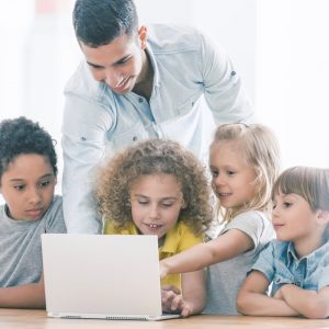 Niños viendo contenido en internet con un adulto